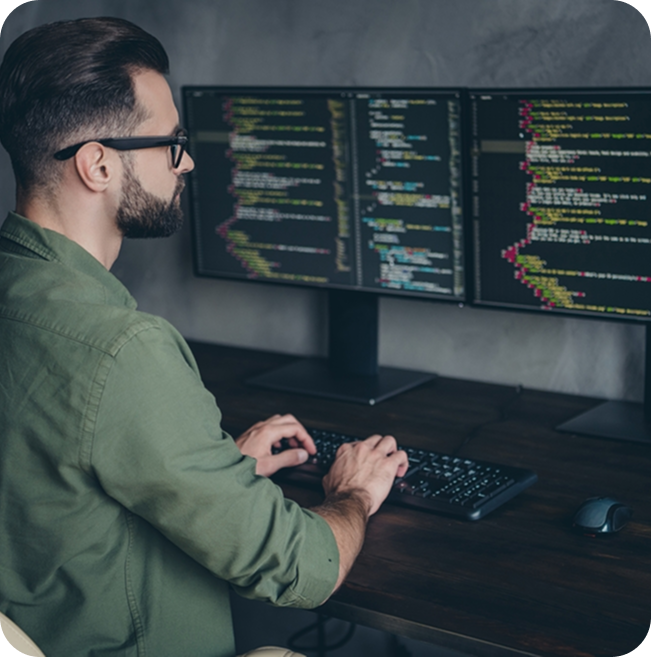 CMS developer working at dual monitors with code on screen